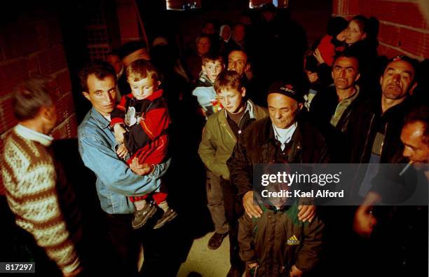 Civilians hide in the basement of an unfinished house where approximately 50 people were taking shelter in Gajre March 25, 2001 as Macedonian forces...