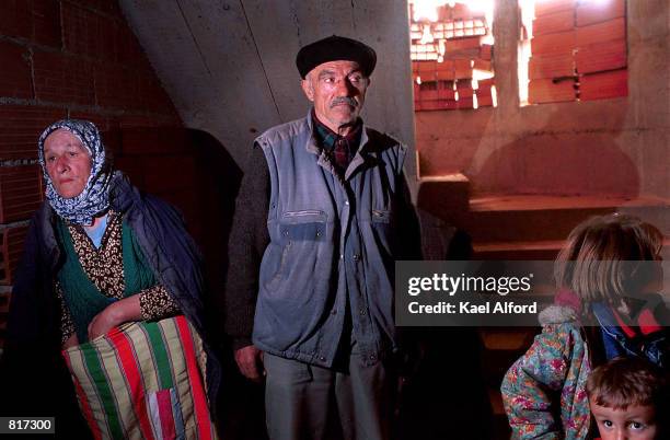 Civilians hide in the basement of an unfinished house where approximately 50 people were taking shelter in Gajre March 25, 2001 as Macedonian forces...