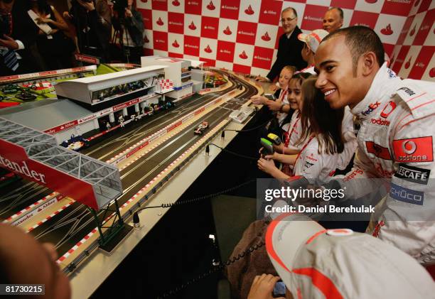 British Grand Prix driver Lewis Hamilton plays Scalextric with children from Great Ormond Street Hospital on the 2008 Abbey and Santander mini...