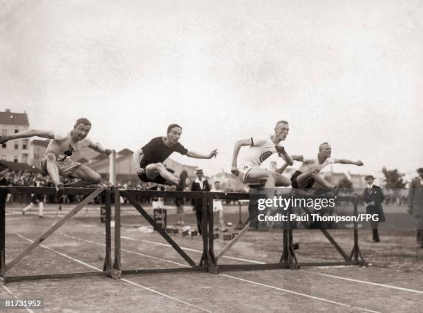 Contestants in the 110 metre hurdles during the German international field meet held by the Berlin Sports Club, circa 1930.