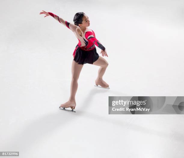 young woman figure skater skating - performing a bauer. - figure skating girl stock pictures, royalty-free photos & images