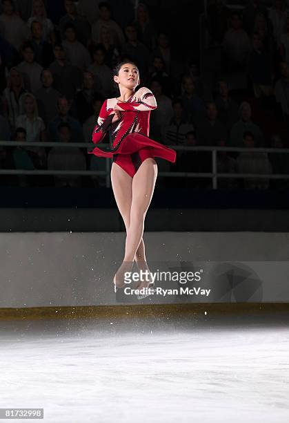 young woman figure skater mid-air performing a triple axel. - フィギュアスケート ストックフォトと画像