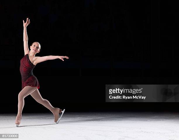 young woman figure skater standing in finishing pose. - kunstschaatsen stockfoto's en -beelden