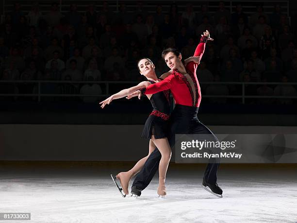 figure skating pair standing in finishing pose - ice skating pair fotografías e imágenes de stock