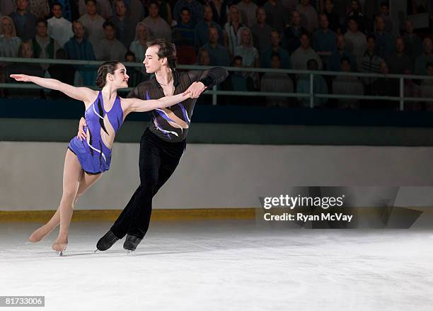 figure skating pair skating side-by-side in the killian position - kunstschaatsen stockfoto's en -beelden