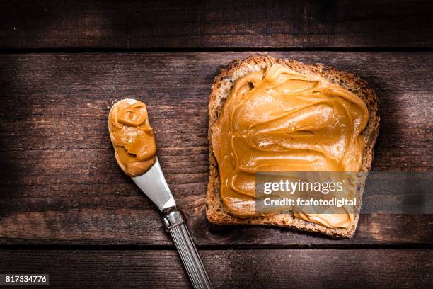 peanut butter toast am rustikalen holztisch erschossen - erdnussbutter stock-fotos und bilder