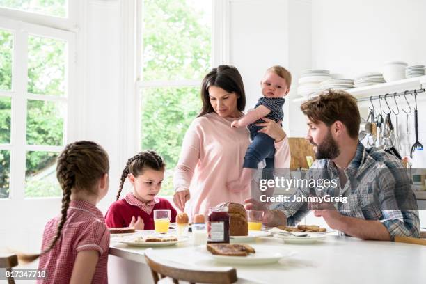 familia sentado en la mesa del desayuno, madre, niño, padre y de las niñas comer - family with three children fotografías e imágenes de stock