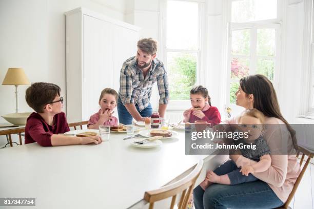 geschäftige moderne familie mit zwei mädchen und zwei jungen frühstücken am esstisch - familie mit vier kindern stock-fotos und bilder