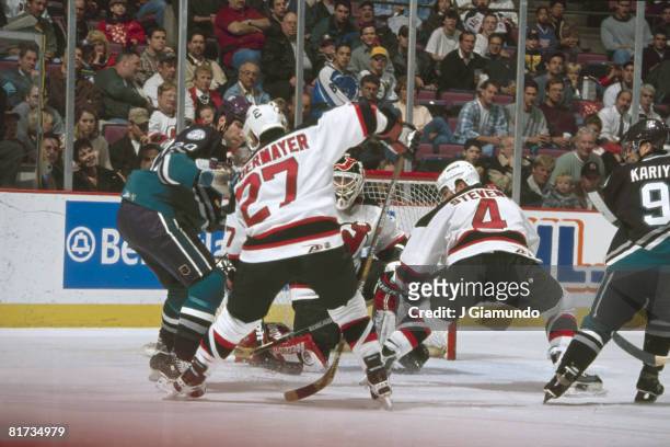 Canadian ice hockey player Scott Niedermayer of the New Jersey Devils and teammate Scott Stevens try to clear the puck from in front of their goal,...