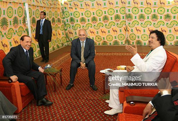 Libyan leader Moamer Kadhafi meets with Italy's Prime Minister Silvio Berlusconi in a tent in the port city of Sirte, 600 kms east of Tripoli, on...