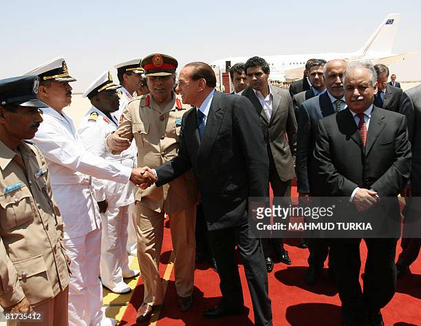 Italy's Prime Minister Silvio Berlusconi shakes hands with Libyan military officials upon his arrival in the port city of Sirte, 600 kms east of...