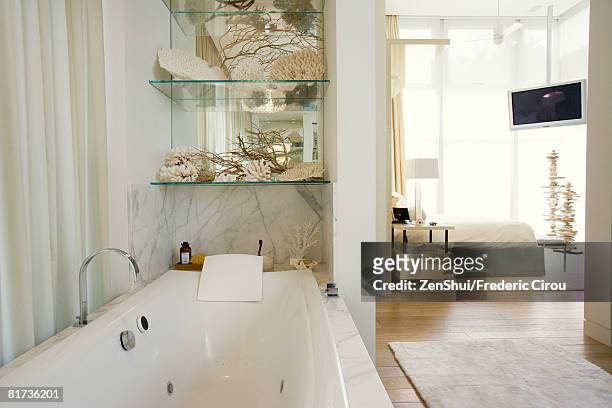 luxury hotel bathroom with large bathtub, bedroom in background - suite photos et images de collection
