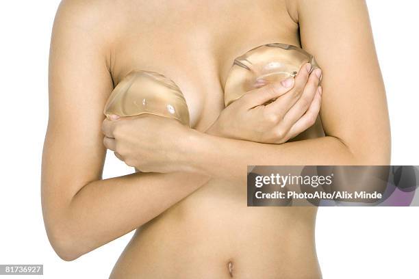 nude woman covering breasts with breast implants, cropped view - silicone bildbanksfoton och bilder