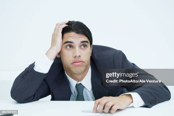 young businessman slouching on desk, holding head - sighing stock pictures, royalty-free photos & images