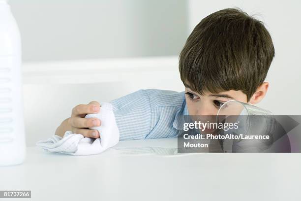 little boy wiping up spilled milk with towel - tea towels stock pictures, royalty-free photos & images