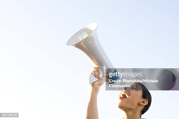 woman shouting into megaphone, low angle view, cropped - culotte sur la tête photos et images de collection