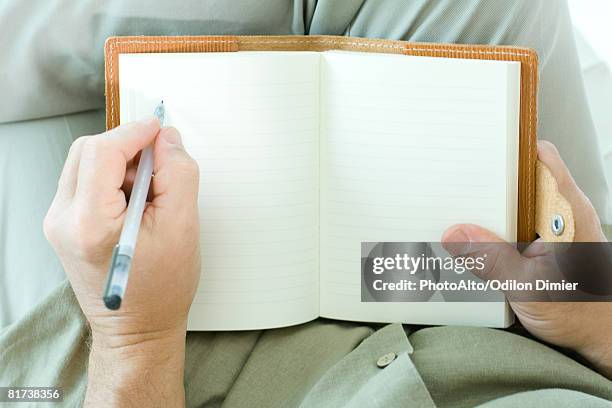 man writing in diary, cropped view of hands - left handed stock pictures, royalty-free photos & images