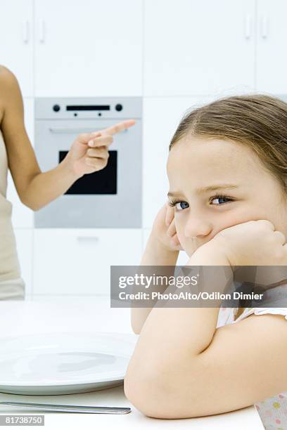 girl sulking at kitchen table, mother shaking finger, cropped view - shaking finger stock pictures, royalty-free photos & images