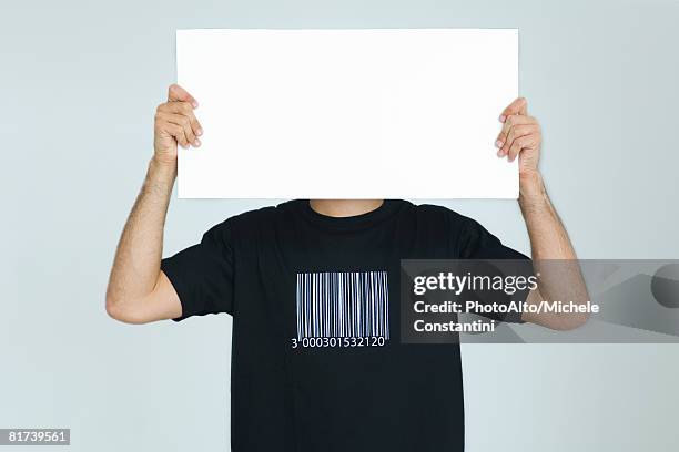 man wearing tee-shirt with bar code, holding blank sign in front of face - bar man t shirt ストックフォトと画像