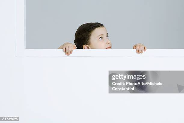 little girl holding onto windowsill, looking up - kid peeking stock pictures, royalty-free photos & images