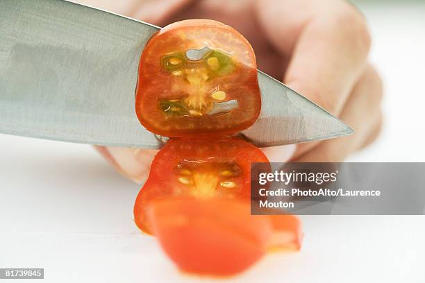 woman slicing tomato with knife, cropped view of hand - plum tomato stock pictures, royalty-free photos & images