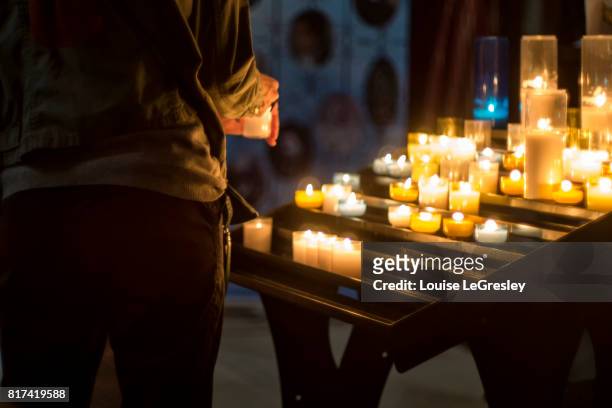 person lighting candle in church - vigília religiosa - fotografias e filmes do acervo