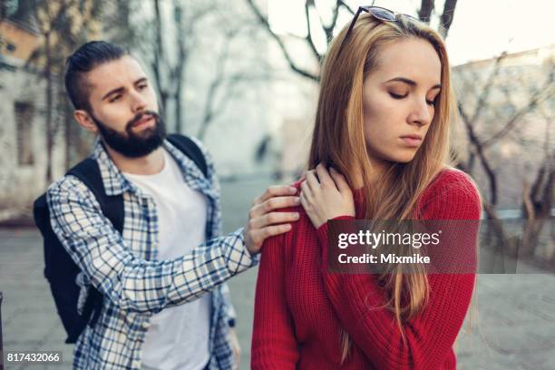 boy reaching out and touching his girlfriend on the shoulder - rudeness stock pictures, royalty-free photos & images