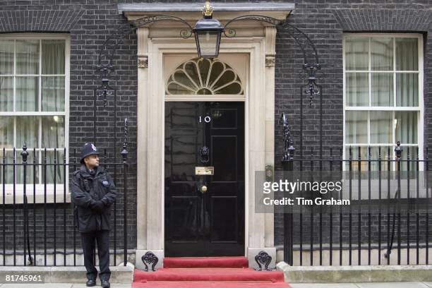 Armed policeman guards Number 10 Downing Street, official home of the British Prime Minister, London, UK