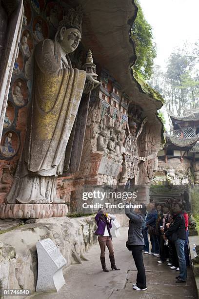 Tourists at Dazu rock carvings of Buddha of Mercy at Mount Baoding, Chongqing, China