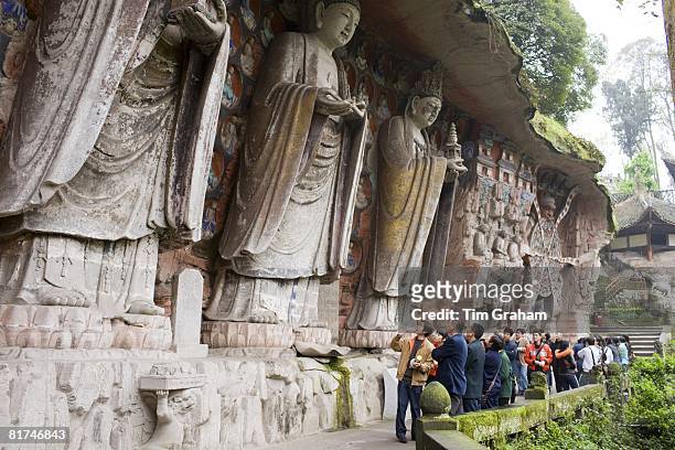 Tourists at Dazu rock carvings of Buddha of Great Sunlight, Buddha of Mercy at Mount Baoding, China
