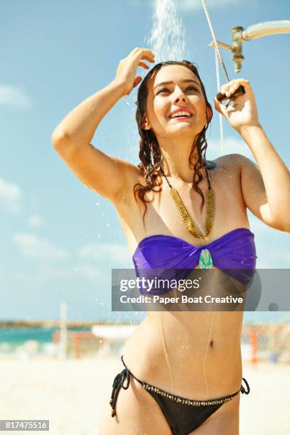 pretty smiling young woman taking a shower on the beach on a hot summer day - hot arabic women 個照片及圖片檔