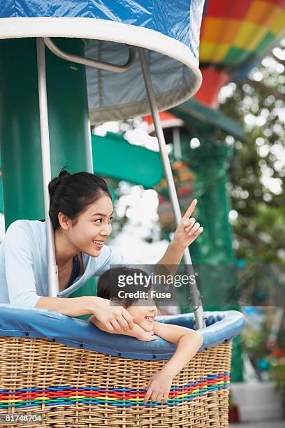 mother and daughter riding amusement ride - hot air balloon ride stock pictures, royalty-free photos & images