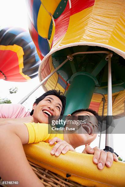 father and son riding amusement ride - hot air balloon ride stock-fotos und bilder