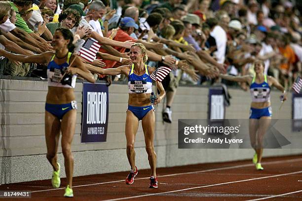 The U.S. Olympic team of Kara Goucher, Shalene Flanagan and Amy Begley celebrate with fans after finsihing in the top three in the women's 10,000...