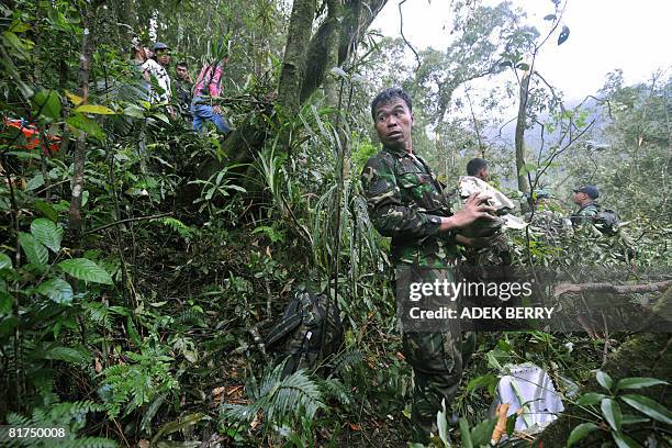 An Indonesian soldier inspects the wreckage of a Casa C-212 plane at the crash site in the jungle of Salak mountain near Cibitung village of Bogor...