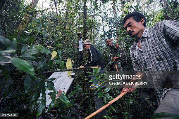 Indonesian soldiers and local villlagers serach for bodies among the wreckage of a Casa C-212 plane at the crash site in the jungle of Salak mountain...