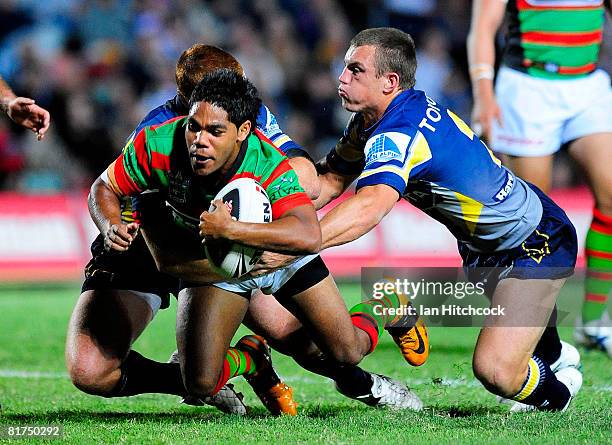 Chris Sandow of the Rabbitohs is tackled by Ben Harris and Steve Southern of the Cowboys during the round 16 NRL match between the North Queensland...