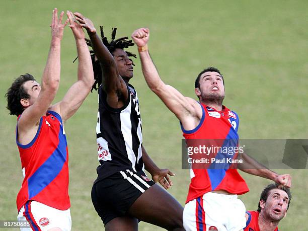 Nick Naitanui of the Swans contests a mark with Daniel Hunt and Luke Tedesco of the Falcons during the WAFL match between the Swan Districts Swans...