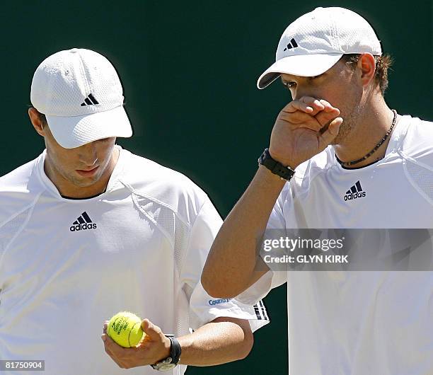 Mike and Bob Bryan of USA discuss tactics as they play in a Men's Doubles match against Czech player Frantisek Cermak and Jordan Kerr of Australia on...