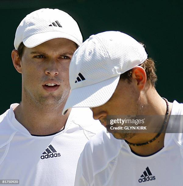 Mike and Bob Bryan of USA discuss tactics as they play in a Men's Doubles match against Czech player Frantisek Cermak and Jordan Kerr of Australia on...