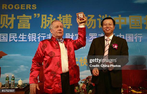 International investor Jim Rogers receives a gift from a local company at a fortune forum held by a Chinese bank and a local newspaper on June 28,...