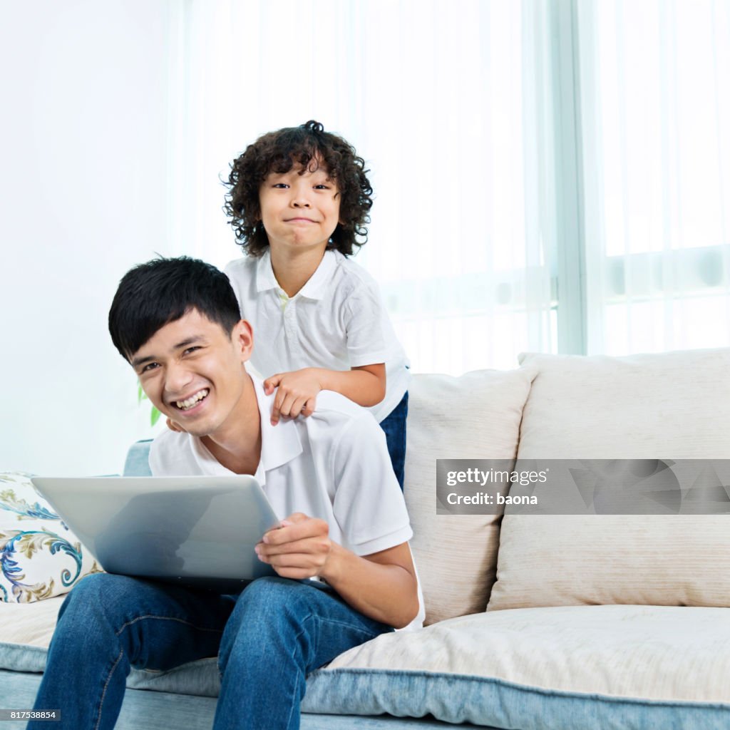 Busy father working at home with son