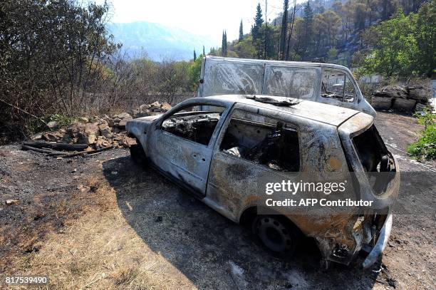 Picture taken on July 18, 2018 shows burned cars in the village of Zrnovnica, near the Adriatic coastal town of Split. Montenegro asked on July 17...