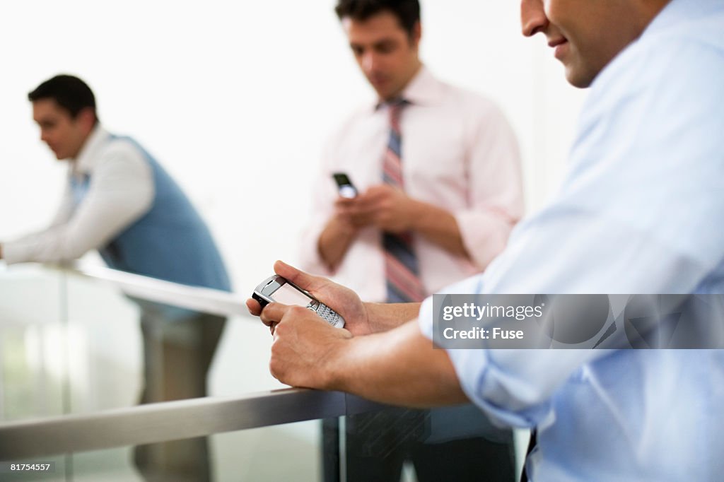 Businessman Using PDA in Hallway