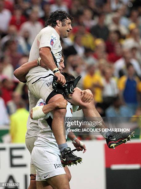 Toulouse's prop Omar Hasan is held by teammates at the end of the French Top 14 rugby union final match Clermont vs. Toulouse at the Stade de France...