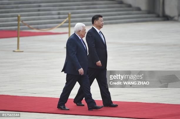 Palestinian president Mahmud Abbas and Chinese President Xi Jinping prepare to inspect Chinese honour guards during a welcome ceremony at the Great...
