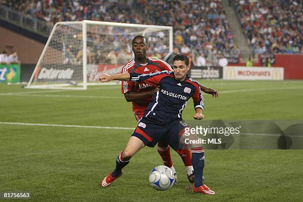 Jay Heaps of the New England Revolution shields the ball from Marvell Wynne of the Toronto FC during the game played at Gillette Stadium on June 28,...
