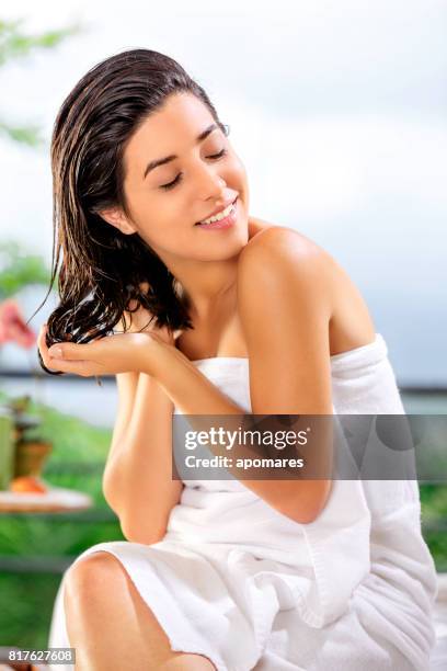 cute and happy hispanic young woman doing self hair treatment after bath - aloe stock pictures, royalty-free photos & images