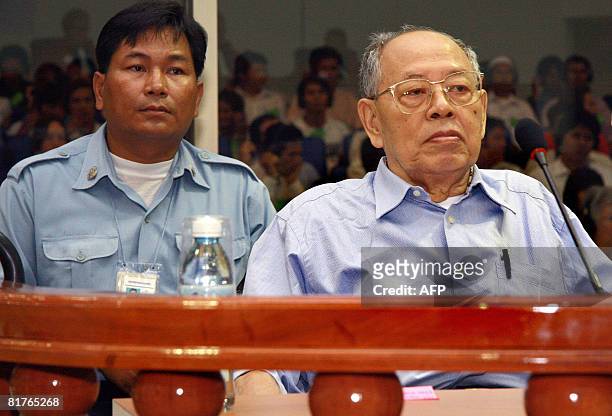 Former Khmer Rouge deputy prime Minister and Minister of Foreign Affairs Ieng Sary sits in dock as a security sits next to him in the Court room...