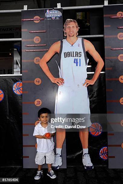 Young fan attends the NBA Nation Tour event at Pier 17 South Street Seaport poses for a photograph with a poster of Dirk Niwiski on June 29, 2008 in...